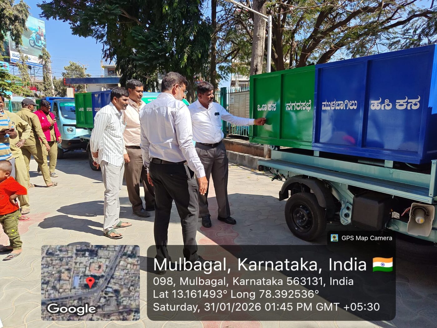Municipal officials examining the dry and wet waste compartments